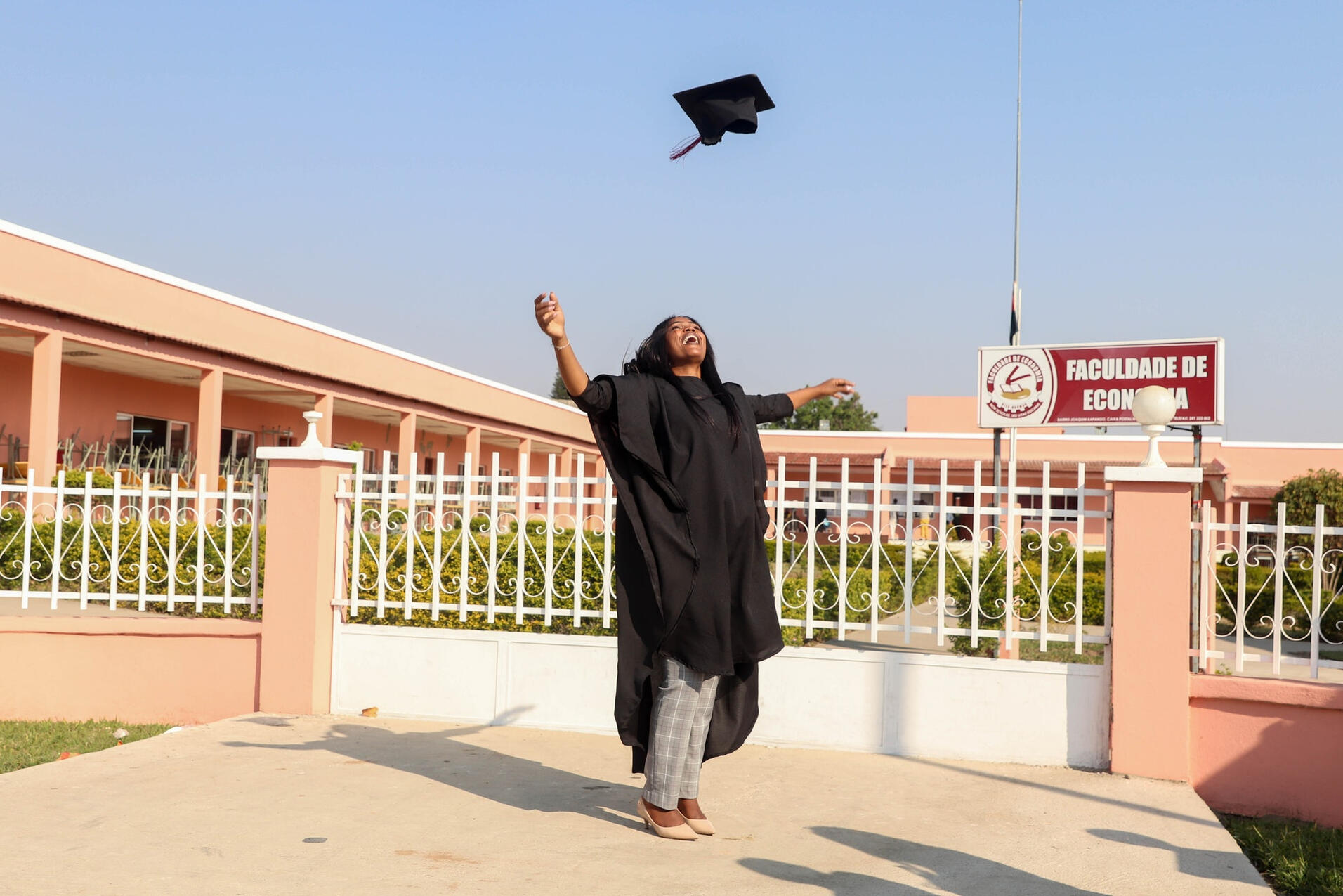 happy graduate throwing cap in the air